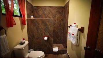 A bathroom with a shower, toilet, and sink.