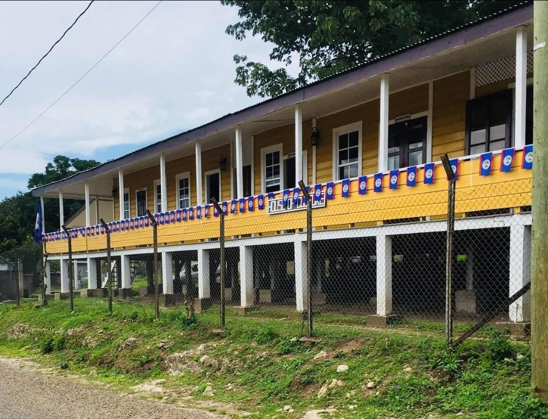 A yellow building with multiple windows and a covered walkway.