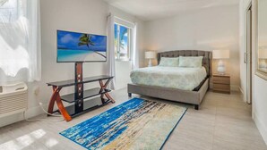 A bedroom with a bed, a TV, a desk, and a window. - Costa Norte Boutique Hotel (Miami Beach)