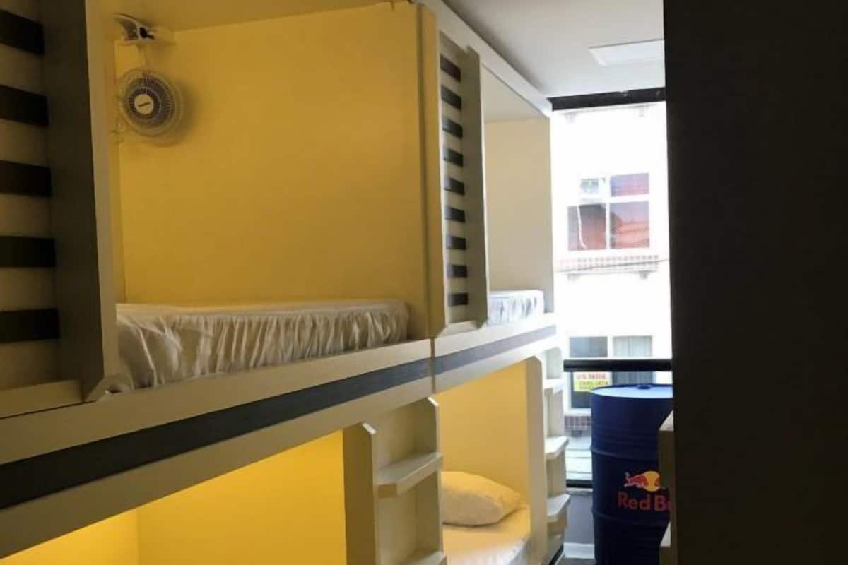 A bunk bed room with a fan and a Red Bull barrel.