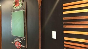 Un mur orné d’une enseigne au style rétro sur laquelle on peut lire : « The Best Way » et « Jack Daniel’s Old No. 7 Whiskey ».