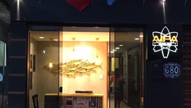 Un bâtiment avec une entrée en verre, une enseigne indiquant « AIPA », et des drapeaux du Brésil, du Mexique et de l’Argentine.
