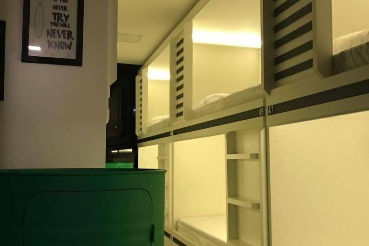 A bunk bed room with a framed quote on the wall and a Heineken cooler.