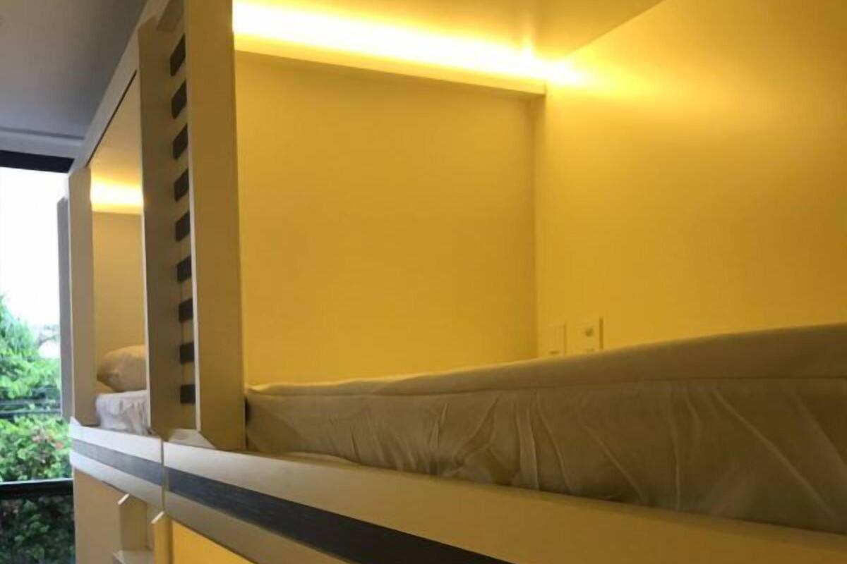A bunk bed with a headboard and a bedside table.
