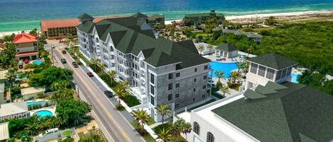 Een resort met meerdere gebouwen, een zwembad en uitzicht op het strand.