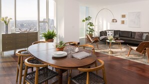 A modern living room with a dining area, large windows, and a city view. - Monet Tower By The Local Way (Mexico City)