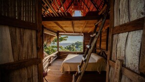 A rustic wooden cabin with two beds and a ladder, overlooking a lush landscape. - Ecolodge Tubagua Puerto Plata (Puerto Plata)