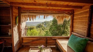 A wooden cabin with a window overlooking a lush landscape. - Ecolodge Tubagua Puerto Plata (Puerto Plata)