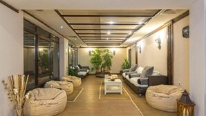 Una sala de estar moderna con sofás, pufs y una mesa de centro.