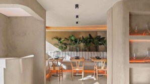 A modern interior with a dining area, a staircase, and a plant wall. - Hotel Mome (San Juan)