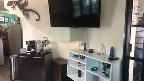 A kitchen with a flat-screen TV mounted above a white shelf unit. - Hotel Ulúa (Veracruz)