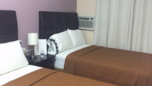 A hotel room with two beds, a nightstand with a lamp, a water bottle, and a window with curtains. - Hotel Ulúa (Veracruz)