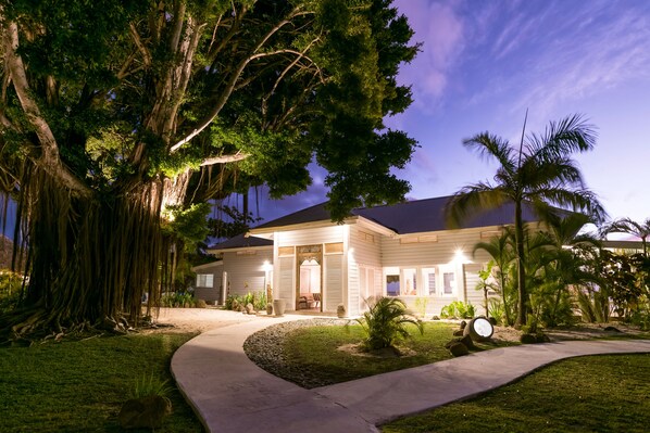 A two-story house with a covered porch, a driveway, and a well-maintained lawn. - Moorea Beach Lodge (Moorea-Maiao)