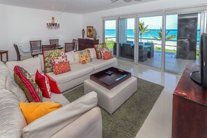 Luxe appartement, 3 slaapkamers, uitzicht op oceaan, aan het strand | Woonkamer | Een flatscreentelevisie en een iPod-dock