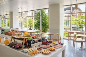 Un buffet proposant une variété de plats, ainsi qu’un intérieur moderne doté de grandes fenêtres.