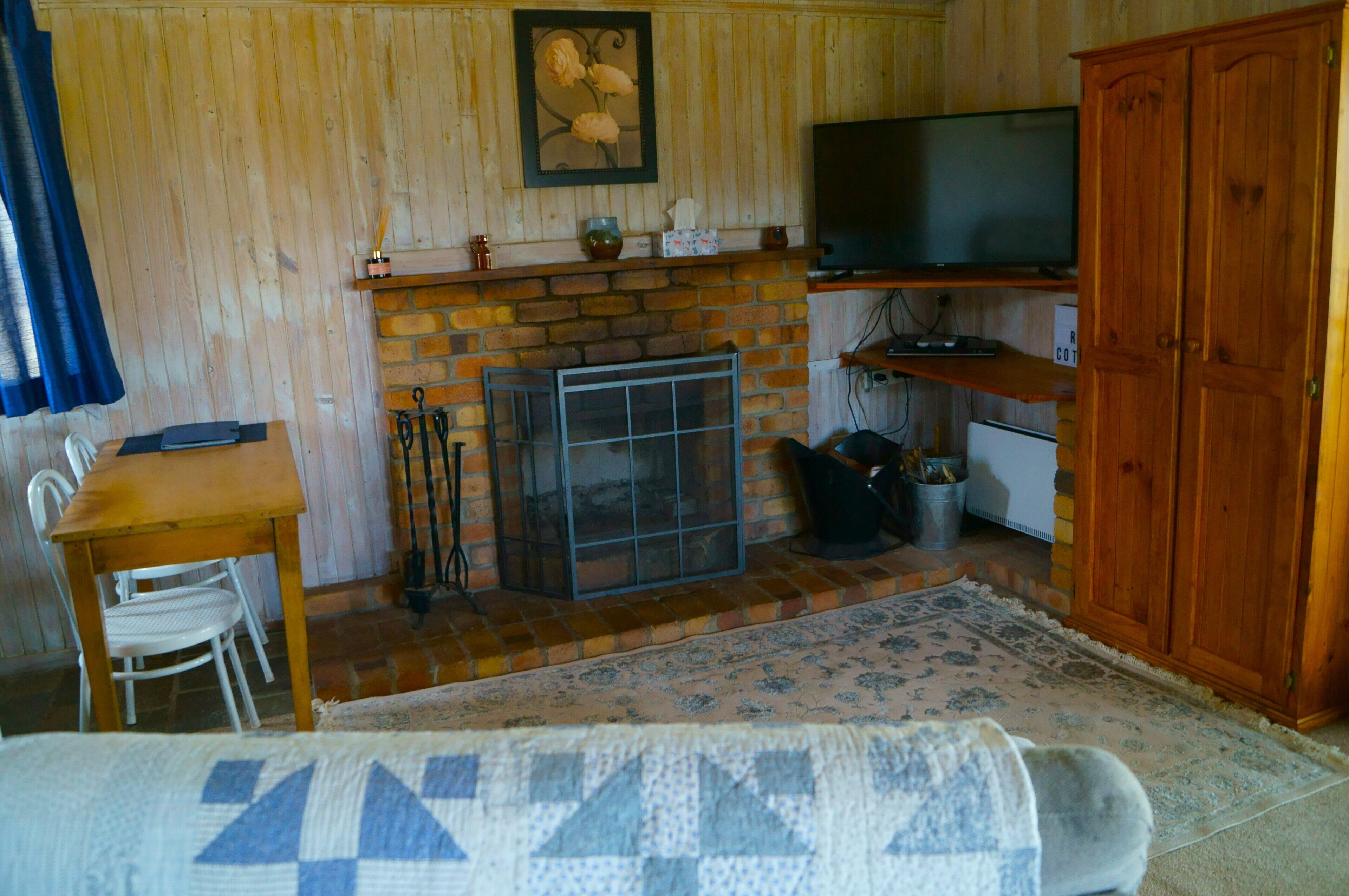 Un salon chaleureux avec une cheminée, un téléviseur et un meuble en bois.