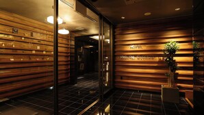 Un vestíbulo de hotel con paneles de madera, una recepción y una planta en maceta.