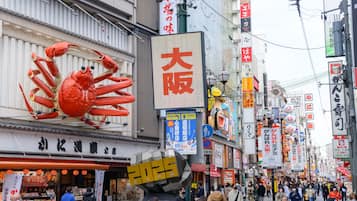 Une rue animée, avec une grande publicité représentant un crabe et divers panneaux en langue étrangère.