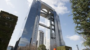 Un rascacielos moderno con una estructura de puente arqueado distintivo.