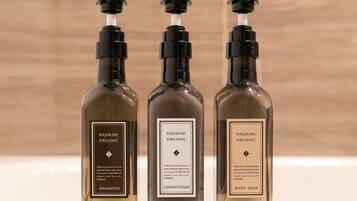 Tres botellas de productos Hajimari Organic sobre una repisa.