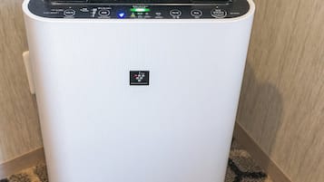 A white air purifier with a control panel featuring multiple buttons and a display screen.