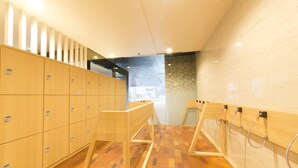 Een moderne badkamer met houten kastjes, een vloer met patroon en een betegelde muur.