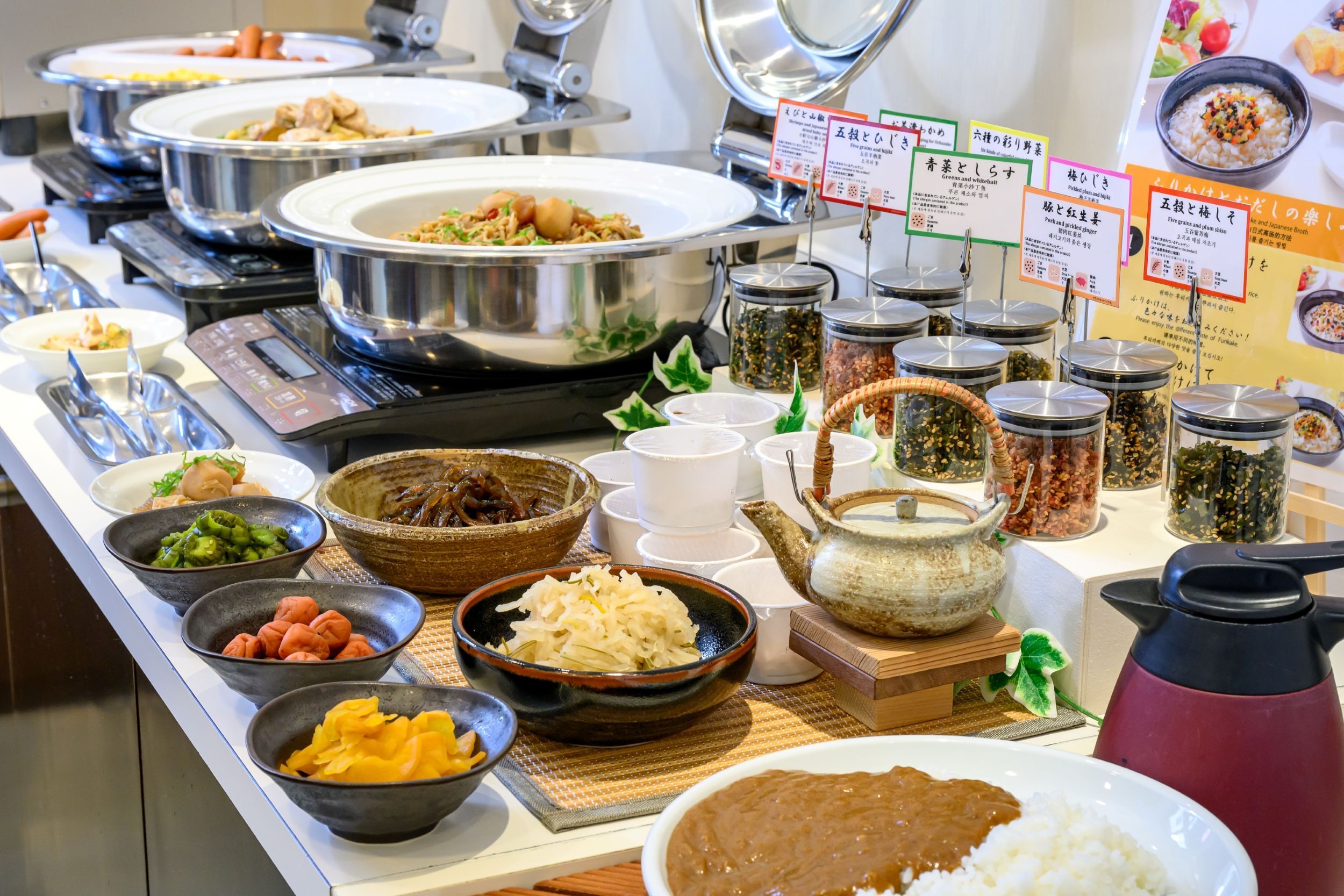 A buffet with various dishes and condiments.