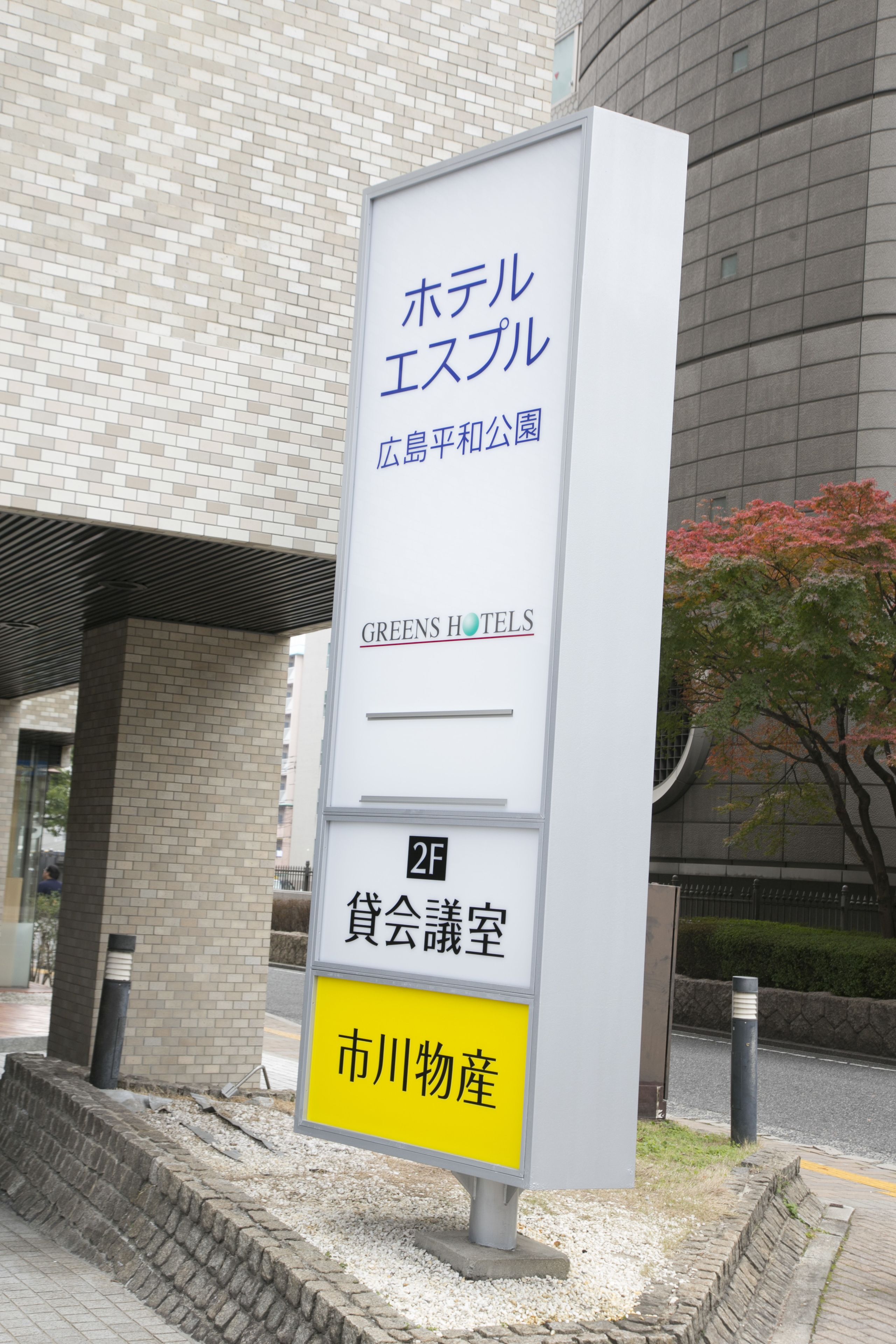 Hotellin kyltti, jossa on japaninkielistä tekstiä ja nimi ”Greens Hotels”.