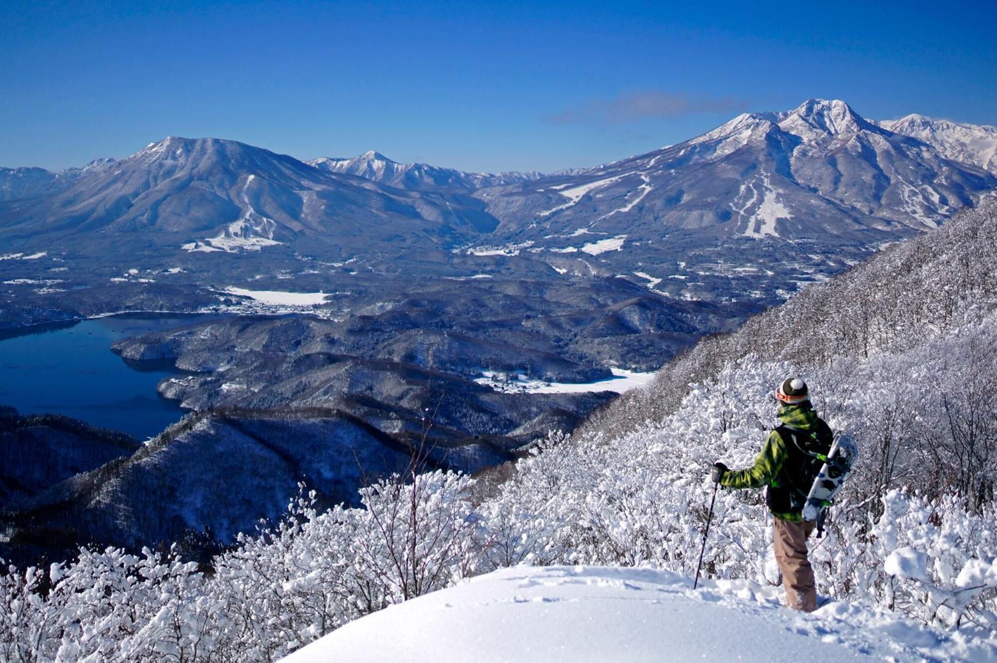 A snowy mountain landscape with a person hiking.
