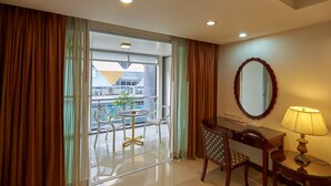 A hotel room with a balcony, a desk, a chair, and a lamp. - Nana Hiso Hotel (Bangkok)