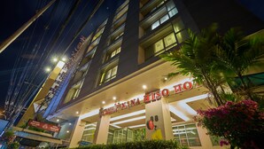 A hotel with a modern facade, multiple floors, and illuminated signage. - Nana Hiso Hotel (Bangkok)