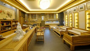 A traditional Japanese tea house with wooden furniture, a reception desk, and a display of tea utensils. - Datong Pipa Hotel (Datong)