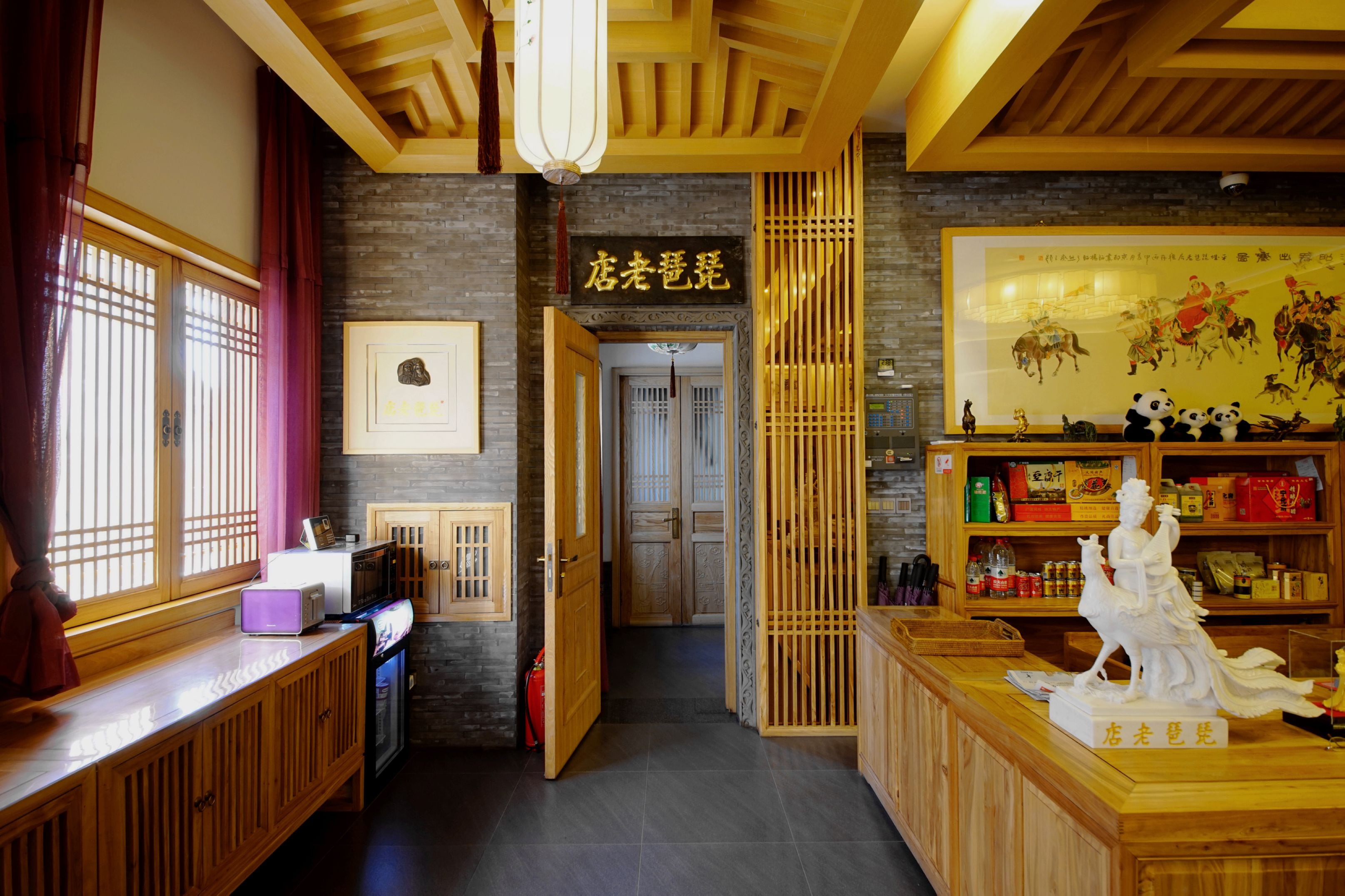 A traditional Chinese restaurant interior with wooden furniture, a display of panda figurines, and a sign reading "店老蛋蛋".