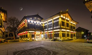 Un bâtiment traditionnel doté d’une cour intérieure, éclairée d’une lumière chaleureuse.