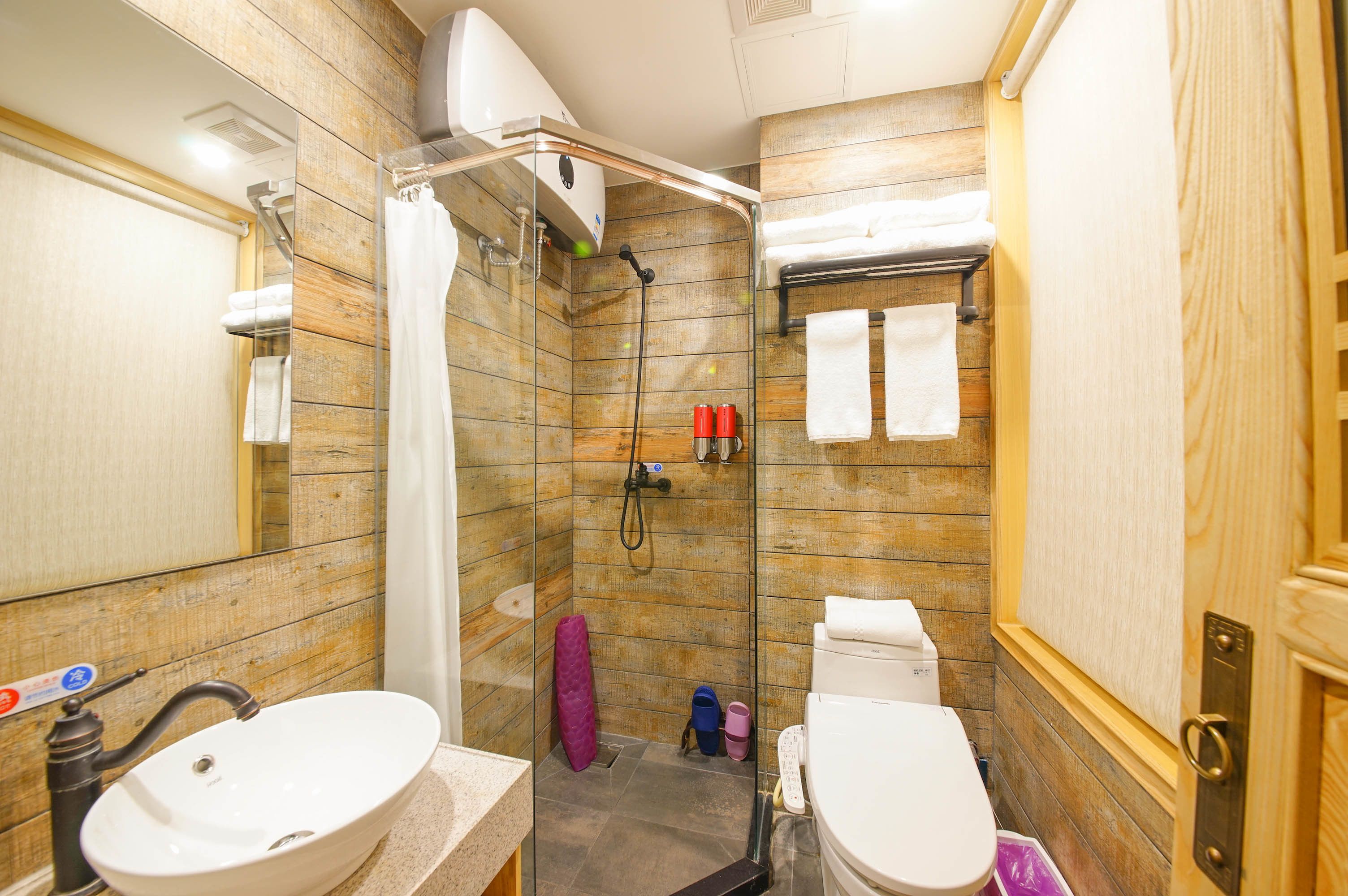 Een badkamer met twee wasbakken, een douche en een toilet.