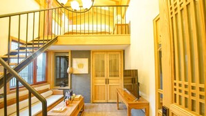 A wooden staircase leading to a loft bedroom with a bed, a desk, and a window. - Datong Pipa Hotel (Datong)