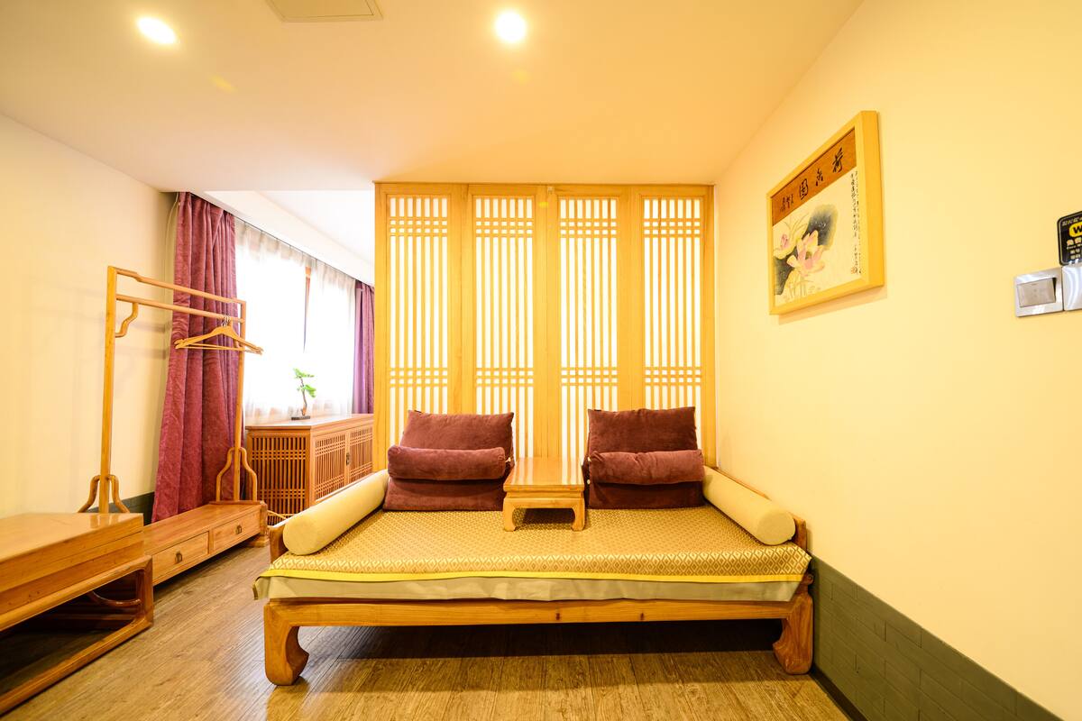 Una habitación tradicional japonesa con futón sobre tatami, muebles de madera y puertas correderas shoji.