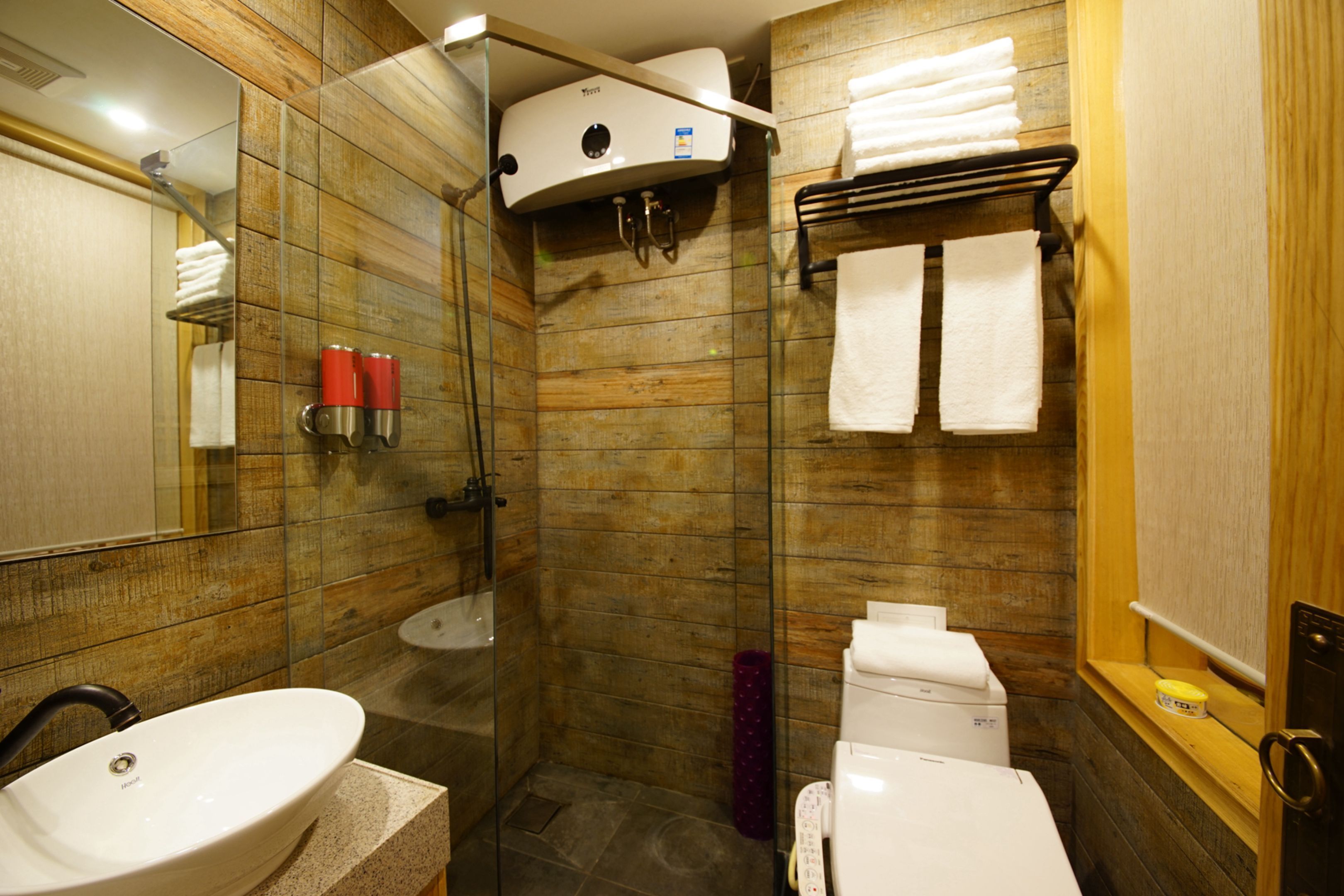 A bathroom with a glass-enclosed shower, a sink, a toilet, and a towel rack.