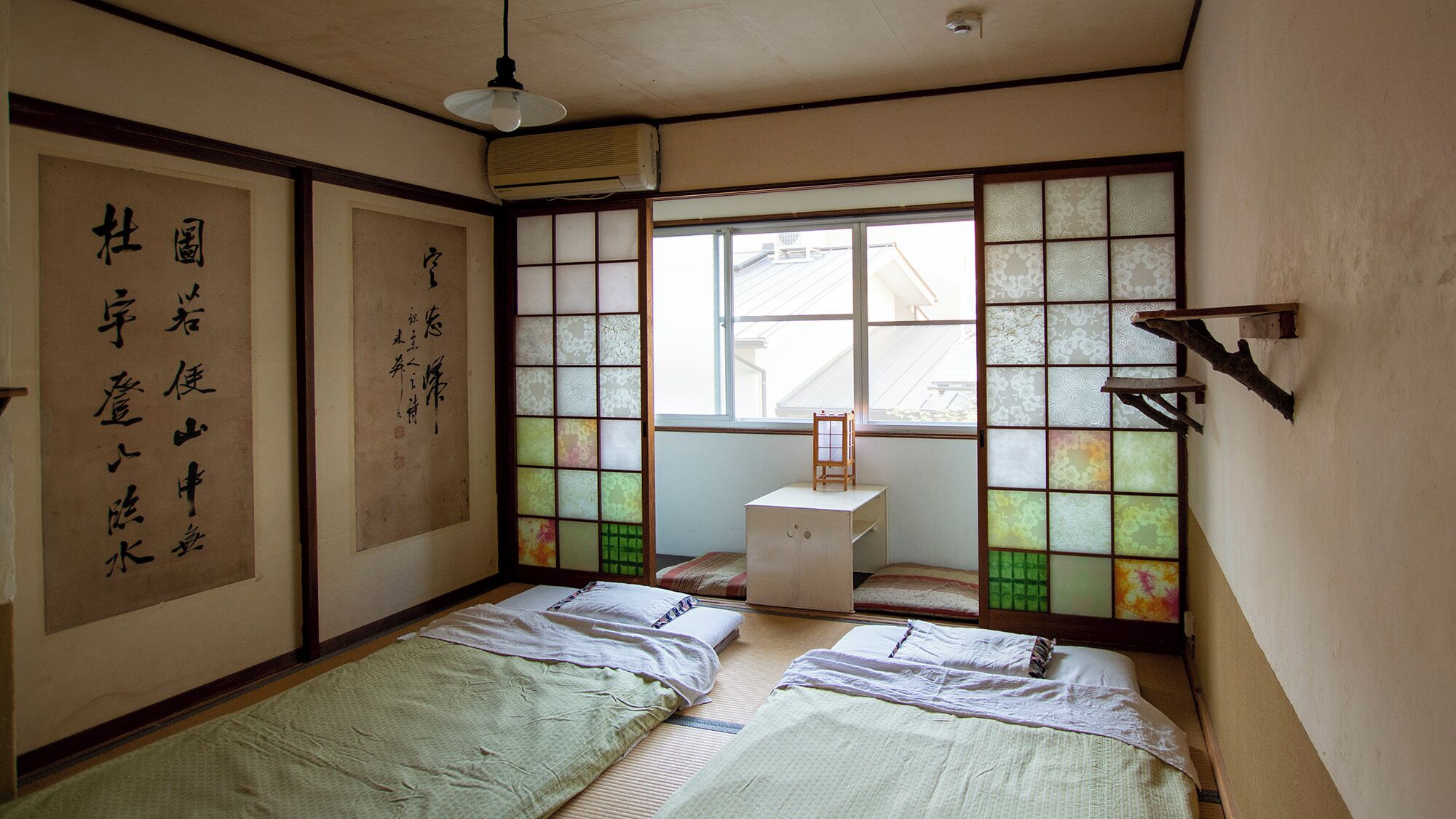 Habitació japonesa tradicional amb paviment de tatami, panells shoji i una petita taula de fusta.