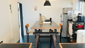 A modern kitchen with a central island, a dining table, and chairs. - Hostel Chapter Two Tokyo (Tokyo)