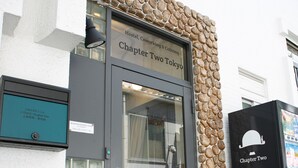 A building entrance with a stone wall, a door with a glass panel, and a sign reading "Chapter Two". - Hostel Chapter Two Tokyo (Tokyo)