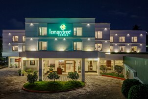 Un hotel moderno con un llamativo letrero que dice 'lemon tree', varios pisos y una entrada bien iluminada.