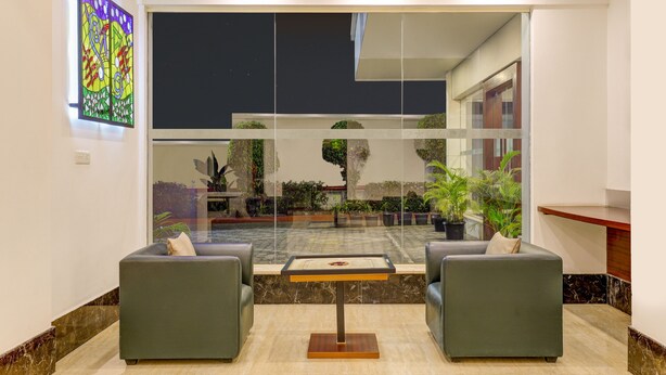 A lobby with two sofas, a coffee table, and a large window overlooking a garden.