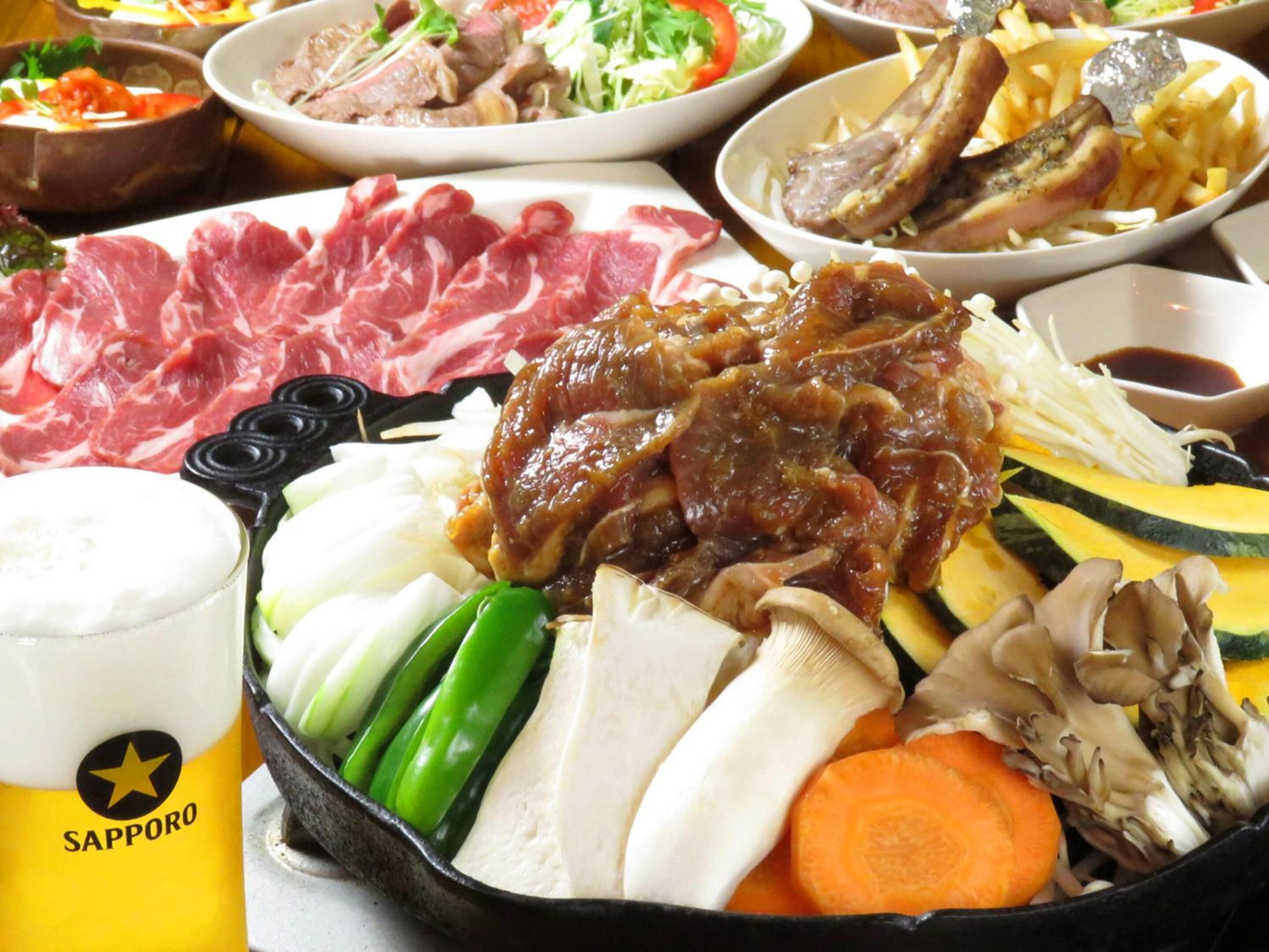 A variety of dishes including sliced meat, vegetables, and a drink labeled 'Sapporo'.