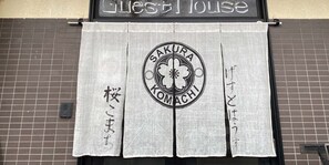 Un restaurante con un letrero que dice 'Sakura Komachi' y una cortina con caracteres japoneses.