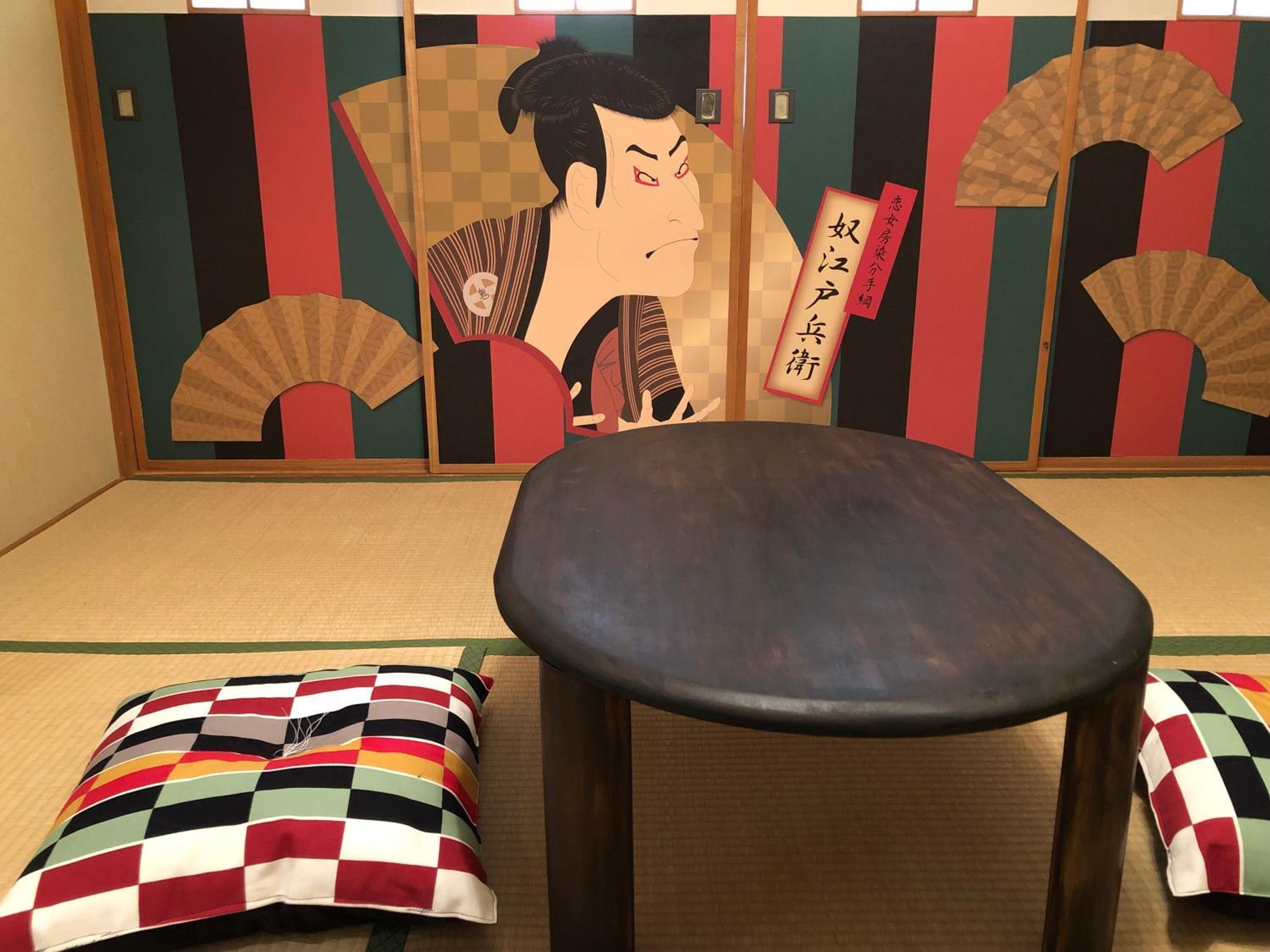 Ein Raum mit Tatami-Matten, einem niedrigen Tisch und zwei Kissen.
