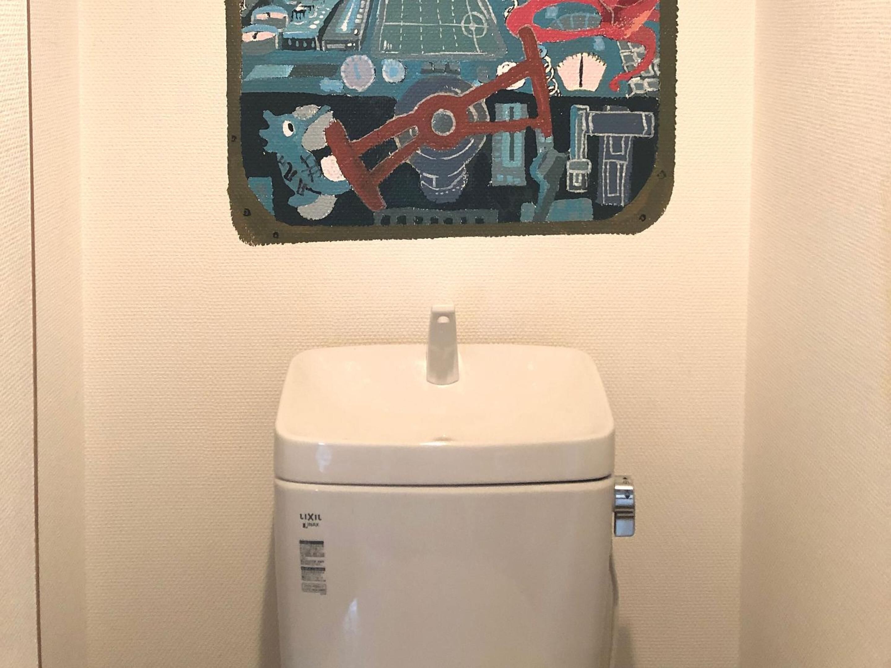 A toilet with a white lid and a control knob on the right side.
