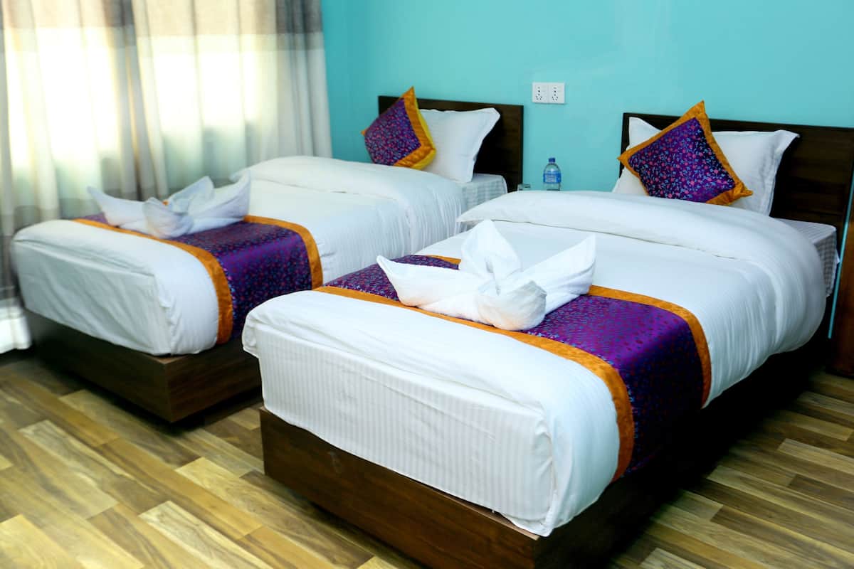 Two double beds with white linens, purple and orange bed runners, and matching pillows.