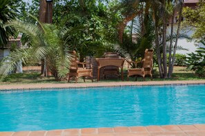 Una piscina al aire libre, sillones reclinables de piscina