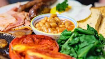 Un plato de comida que incluye frijoles, tomates, espinacas y otros ingredientes.